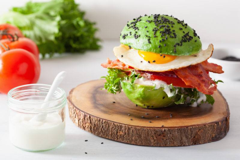 A burger made using avocado halves as burger buns