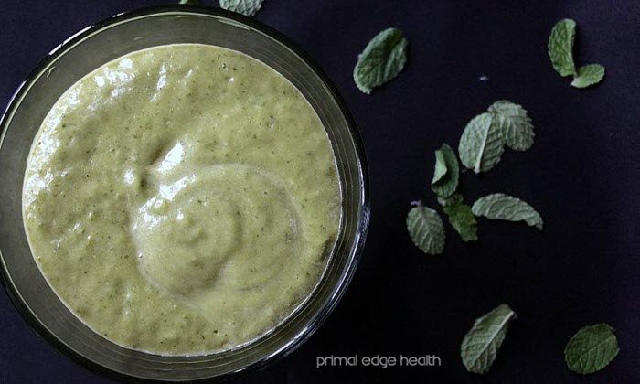 Top down image of a green smoothie on a black background