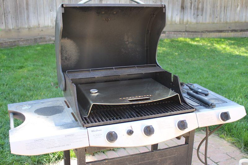 Kettlepizza stainless steel pizza-making insert for gas grills on an old barbecue in the backyard