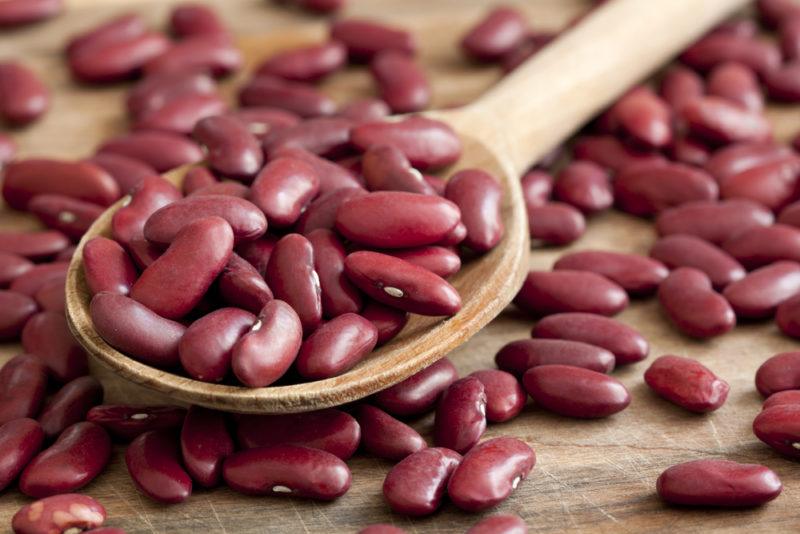 Kidney beans on a spoon and a table