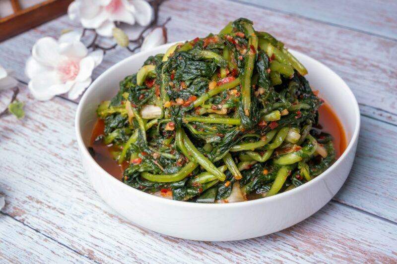 A white bowl containing a delicious dish of kimchi that has been made using young summer radishes, also called yeolmu