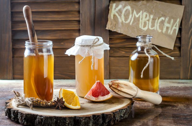 Three glass jars of kombucha with different flavorings