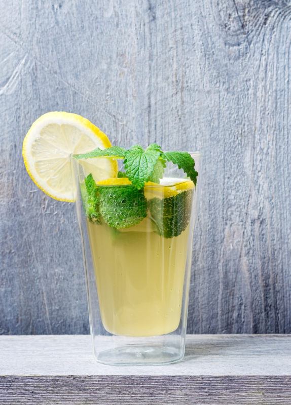 A glass of lacto fermented soda with lemons and mint leaves