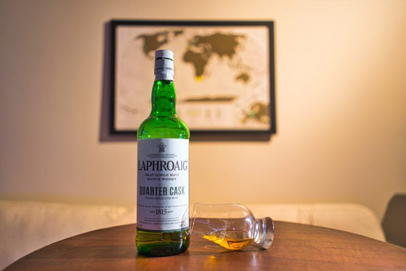 Laphroaig quarter cask bottle with snifter in dimly lit room