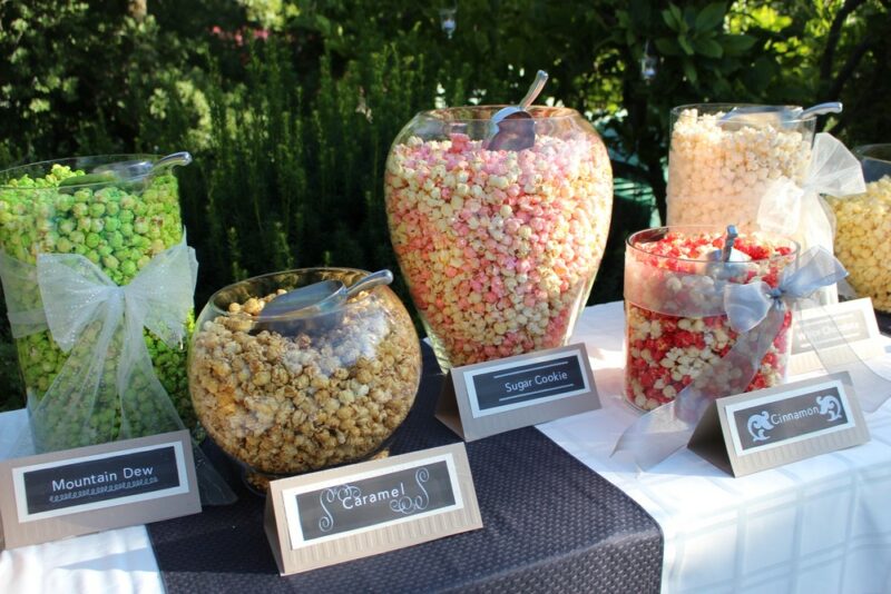 Large containers of fresh popcorn on a table outside for a popcorn party