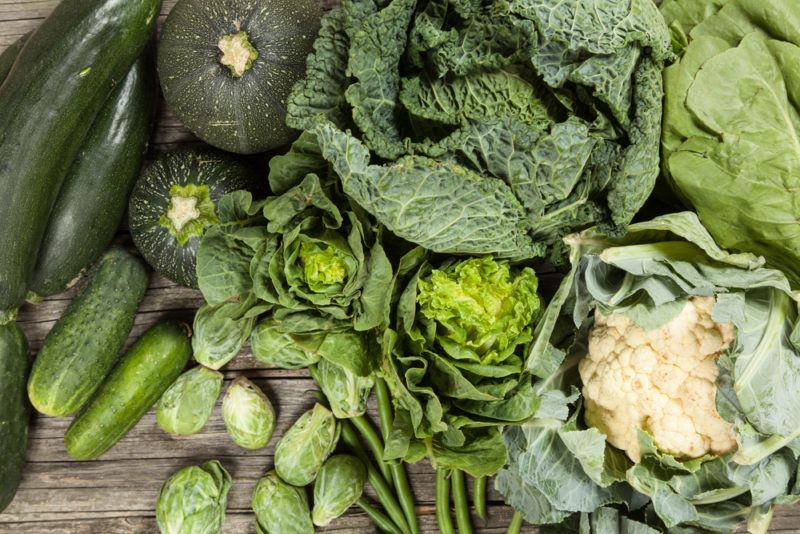 A selection of leafy greens on a wooden table