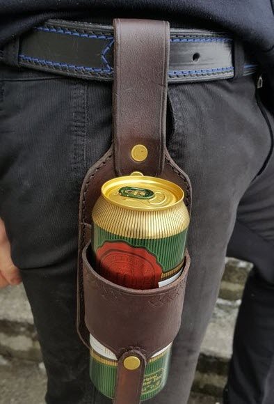 Man with a beer holster and a can of beer in it. 