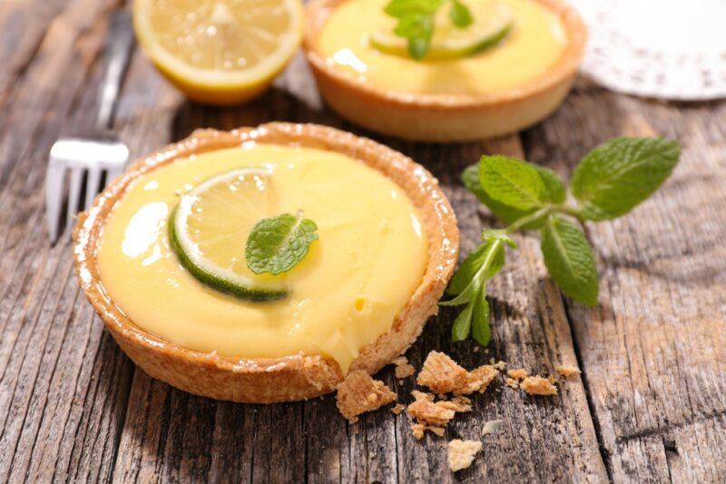 Two lemon tarts with a slice of lemon on top