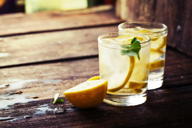 Two glasses of lemon water on a wooden table