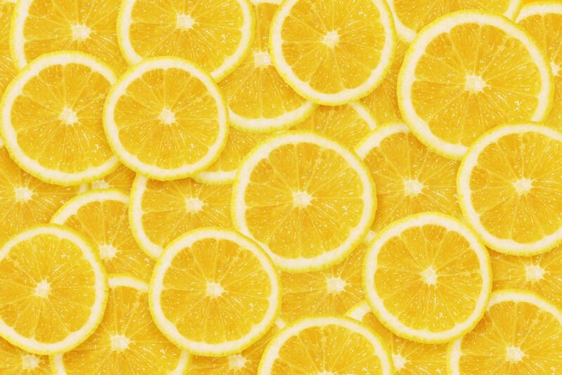 This photo shows an overhead view of several slices of bright yellow lemons.