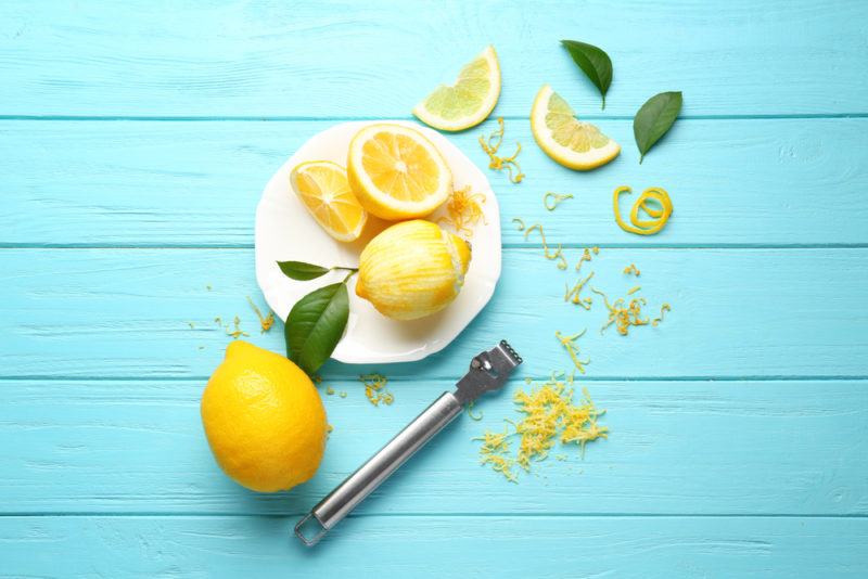 Lemons and lemon zest on a blue table