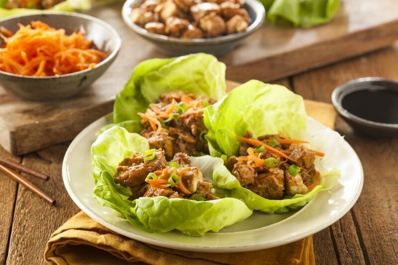 A plate with lettuce that is being used as a type of wrap