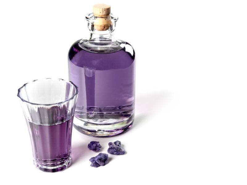 A bottle and a glass of violet liqueur