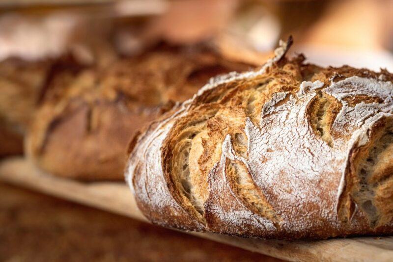 A wooden tray with loaves of freshly baked bread