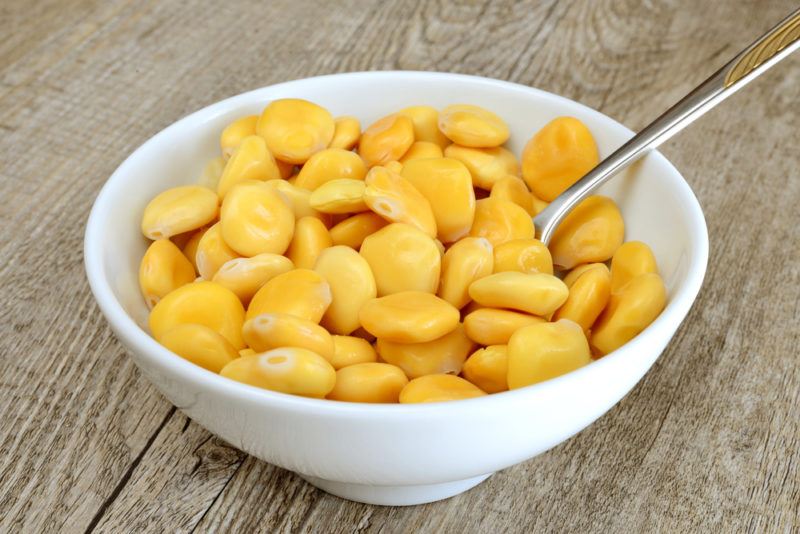 A white bowl of yellow lupins and a spoon