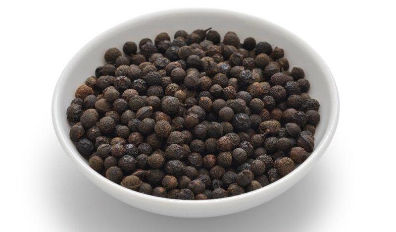 on a white surface is a white bowl with magao or mountain peppercorns