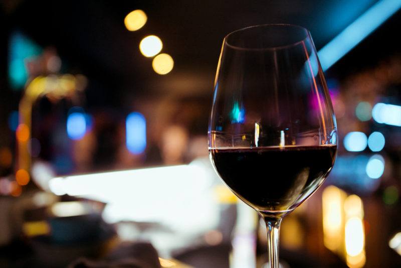 A glass of malbec wine against an out-of-focus restaurant scene