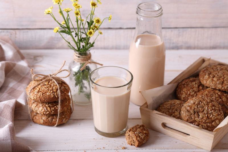 A glass and a bottle of malt milk, next to some baking