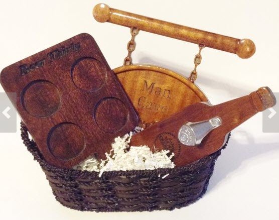 Basket containing a beer glass tray, a bottle opener and a Man Cave sign.