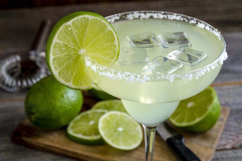 A green margarita with ice in a salt rimmed glass