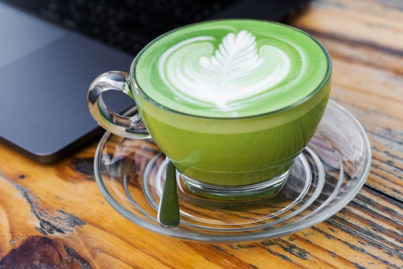 A glass mug containing matcha tea latte