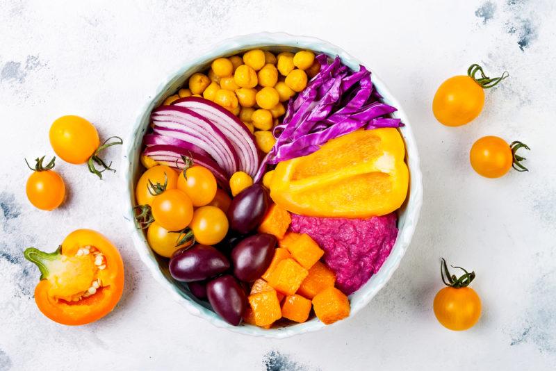 A white bowl with different purple and orange ingredients