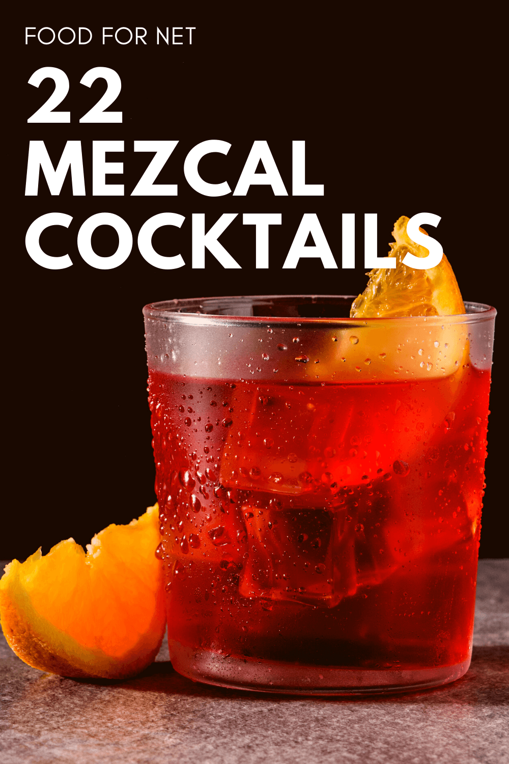 A glass containing a mezcal negroni with an orange wedge