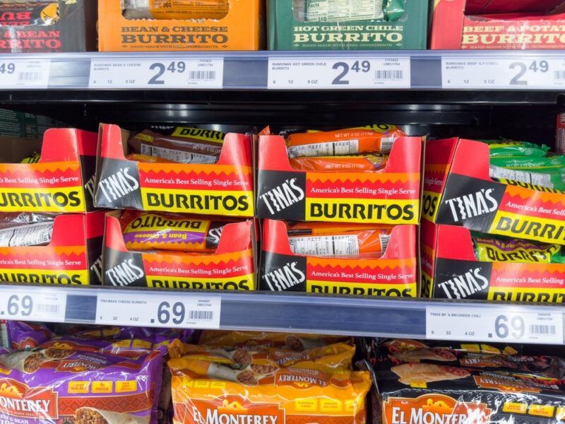 A grocery store shelf with a collection of microwaved burritos