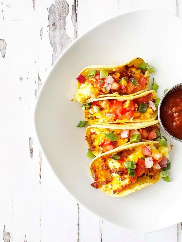 A large white plate containing three mini air fryer breakfast tacos