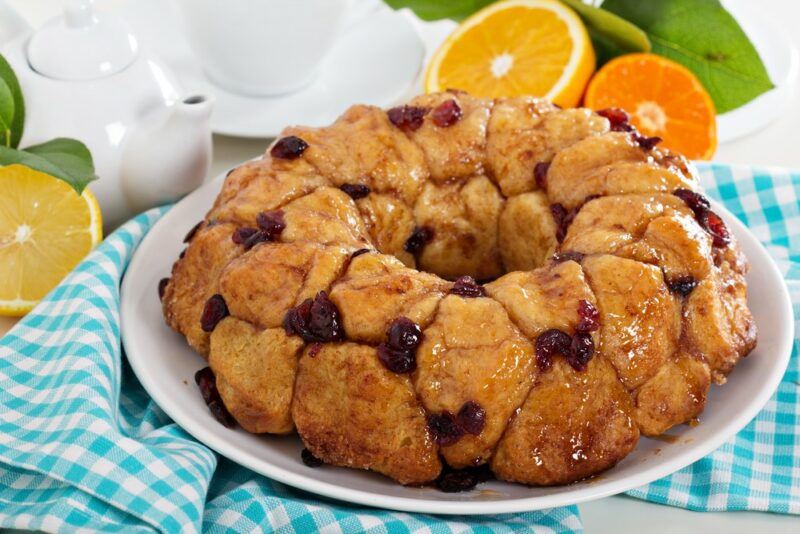 A white plate with monkey bread that's been dotted with dried fruit