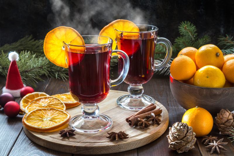 Two glasses of mulled wine with cut lemons and seasonal decorations