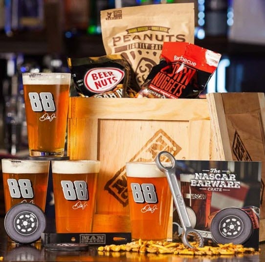 Crate with various snacks, NASCAR gear and beer mugs. 