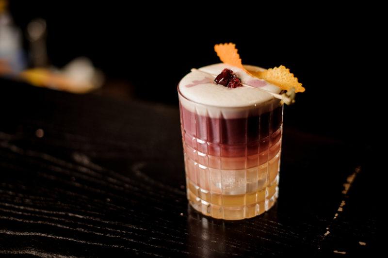 A New York sour cocktail against a black background