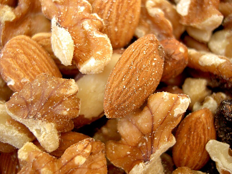 This closeup photo shows a mix of almonds and pecans.