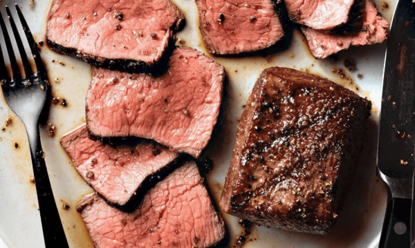 Set of steaks on a table with a knife and fork