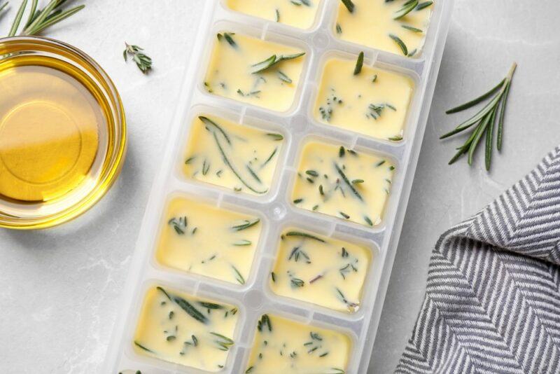 Ice cube trays that contain frozen olive oil with herbs