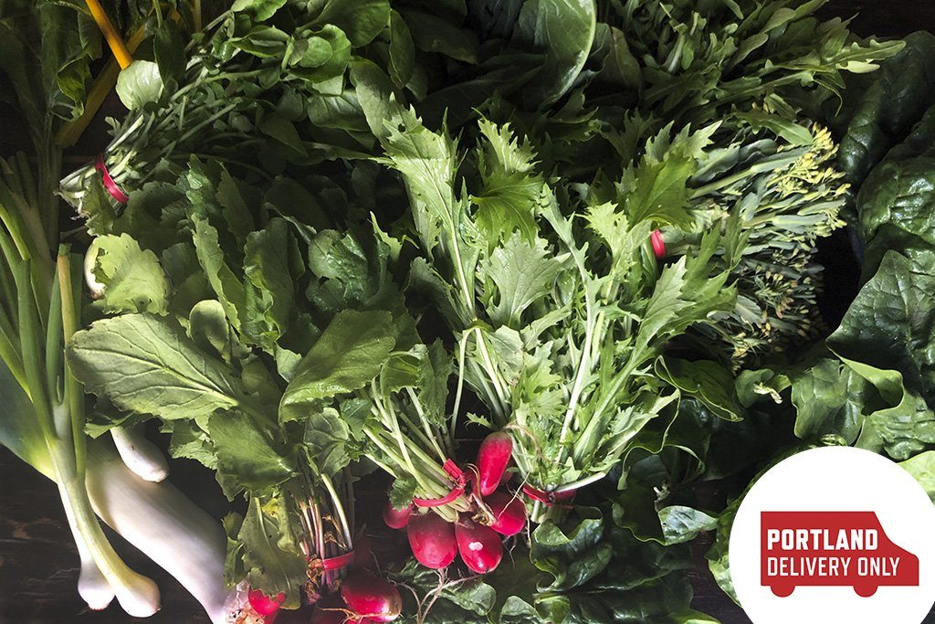 A PHOTO FILLED WITH GREENS SUCH AS LEEKS, SCALLIONS, RADISHES WITH GREENS ATTACHED, HERBS, KALE, LETTUCE, AND ARUGULA.  IN THE LOWER RIGHT CORNER IS A RED SILHOUETTE OF A DELIVERY TRUCK WITH WHITE STENCIL LETTERS SAYING, PORTLAND DELIVERY ONLY