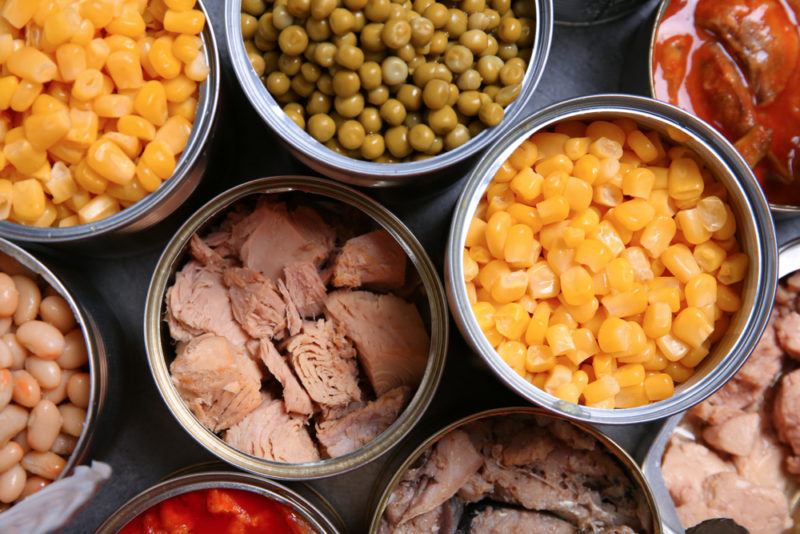 Open tins of food, including tuna, corn and peas