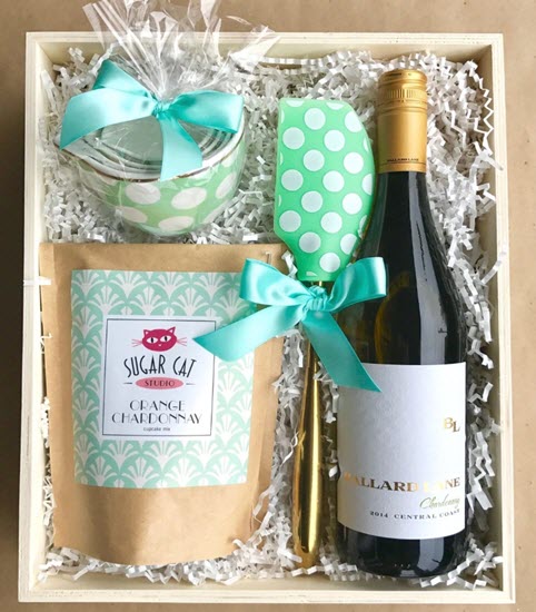Orange Chardonnay Boozy Baking Gift Box | Food For Net A box containing cupcake mix, a spatula, wine and cupcake cups.