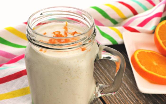 A smoothie with orange zest in a mason jar