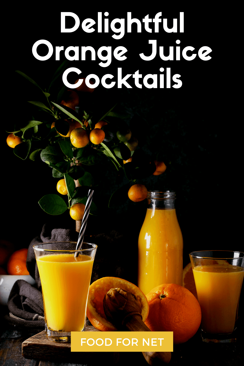 Two glasses of orange juice near a large bottle of orange juice with oranges on the table