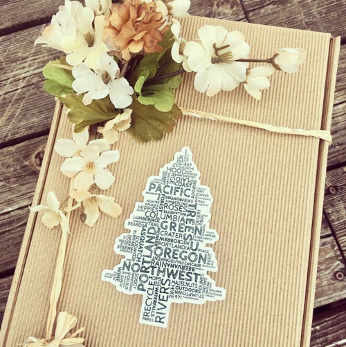 Oregon Wine Country Gift Box | Food For Net A cardboard box with a pine tree and flowers.