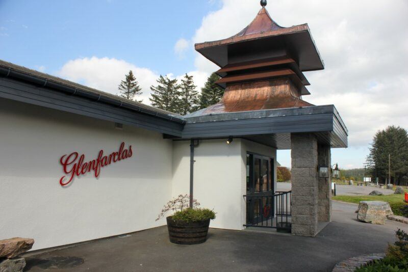 Outside the Glenfarclas distillery in Speyside, showing the Glenfarclas logo written on a white wall