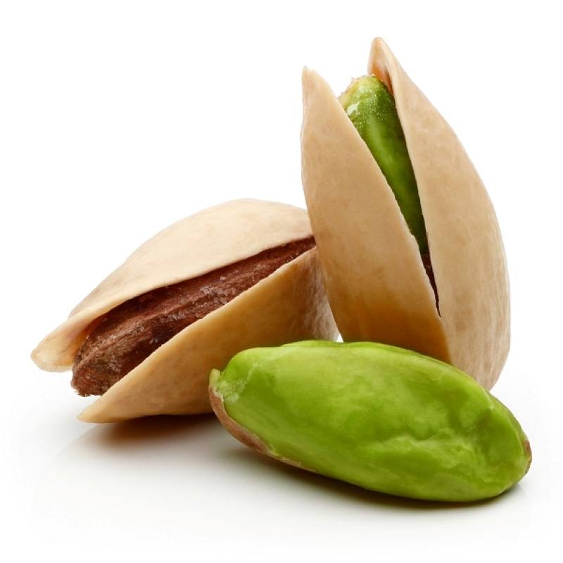 Three pistachios, two still in the shell, one lying on its side and one sitting straight up, the third pistachio has its green skin but is shelled laying in front of the two others