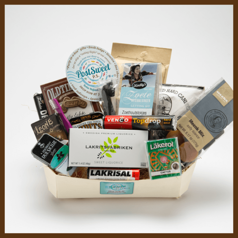 Post Sweet cardboard basket full of international licorice candies, with the post sweet logo on the front of the basket and a post sweet round sticker resting on the top of the candy display