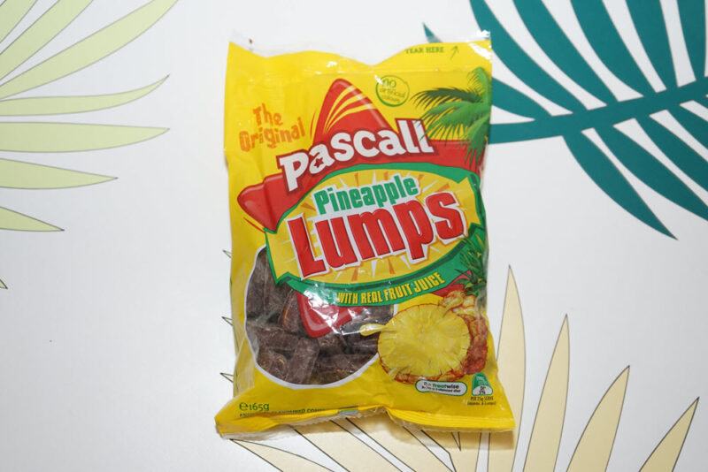 A bag of Pascall Pineapple Lumps on a background with green and yellow leaves