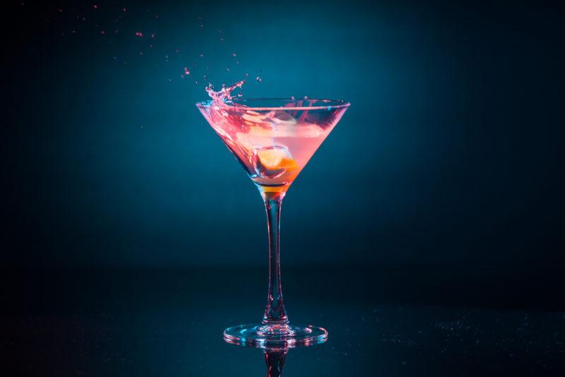 A pink passion cocktail against a dark background