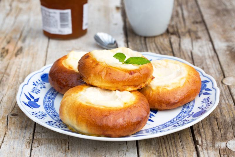 Four pastries with cottage cheese on a blue and white plate