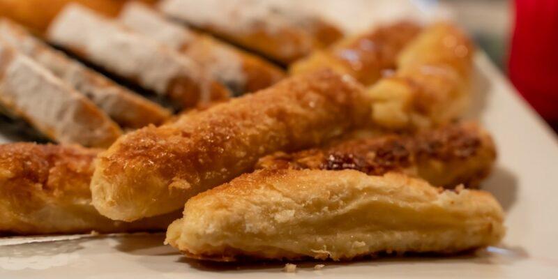 A white plate with a dish of pastry quesitos that have been cooked