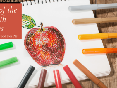 A notebook with an apple drawn on it, surrounded by various colored pens